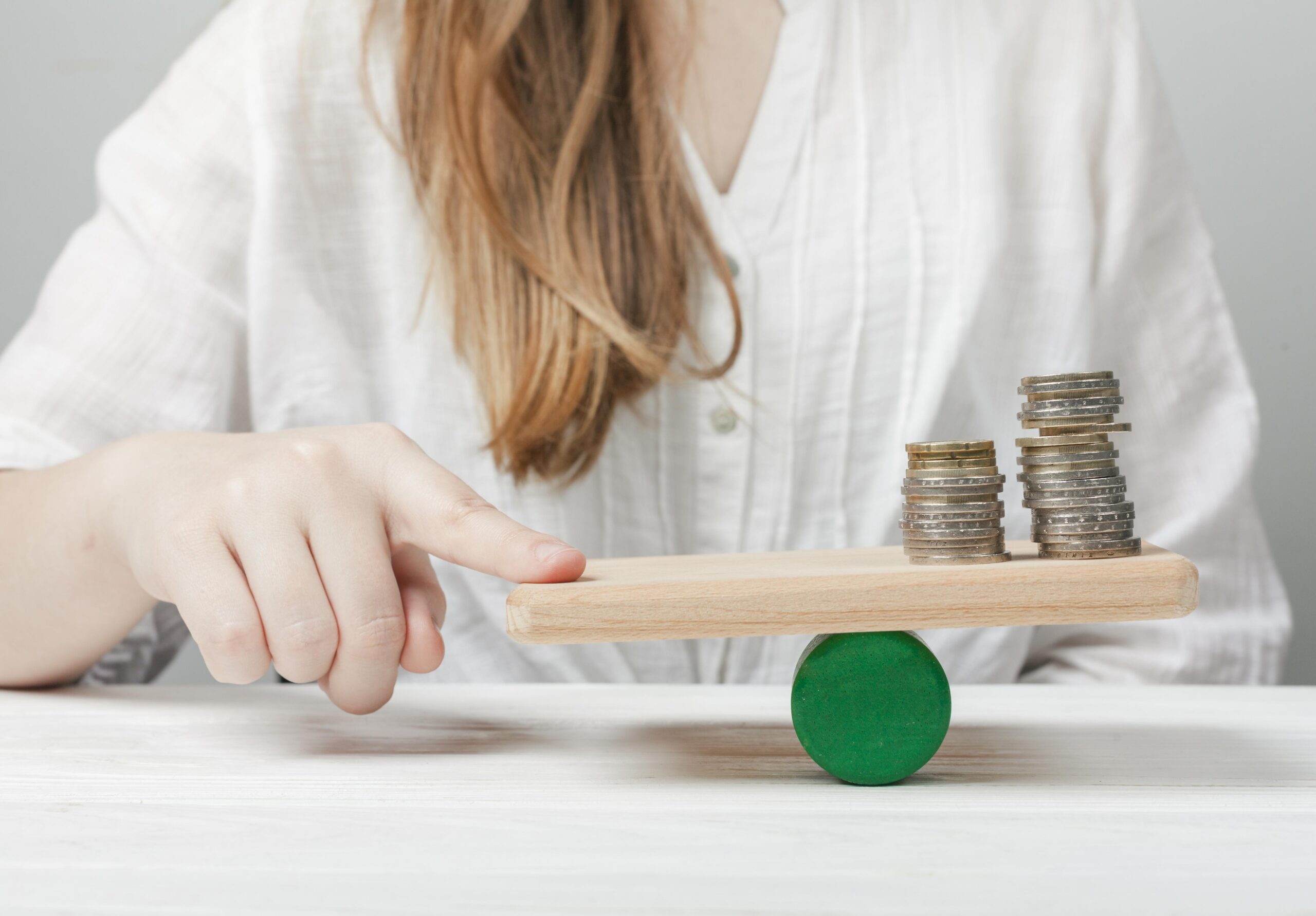 woman-holding-her-finger-balance-with-coins